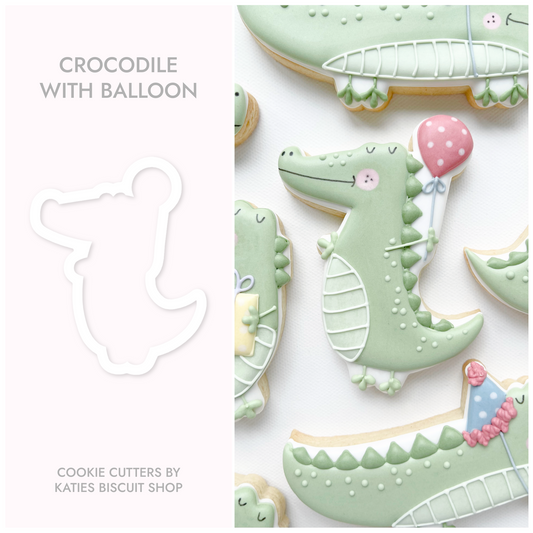 3D printed cookie cutter by katies biscuit shop in the shape of a crocodile holding a balloon 