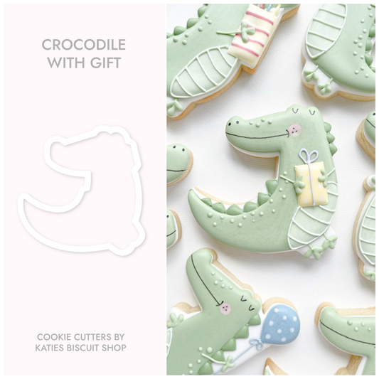 3D printed cookie cutter by katies biscuit shop in the shape of a crocodile holding a gift 