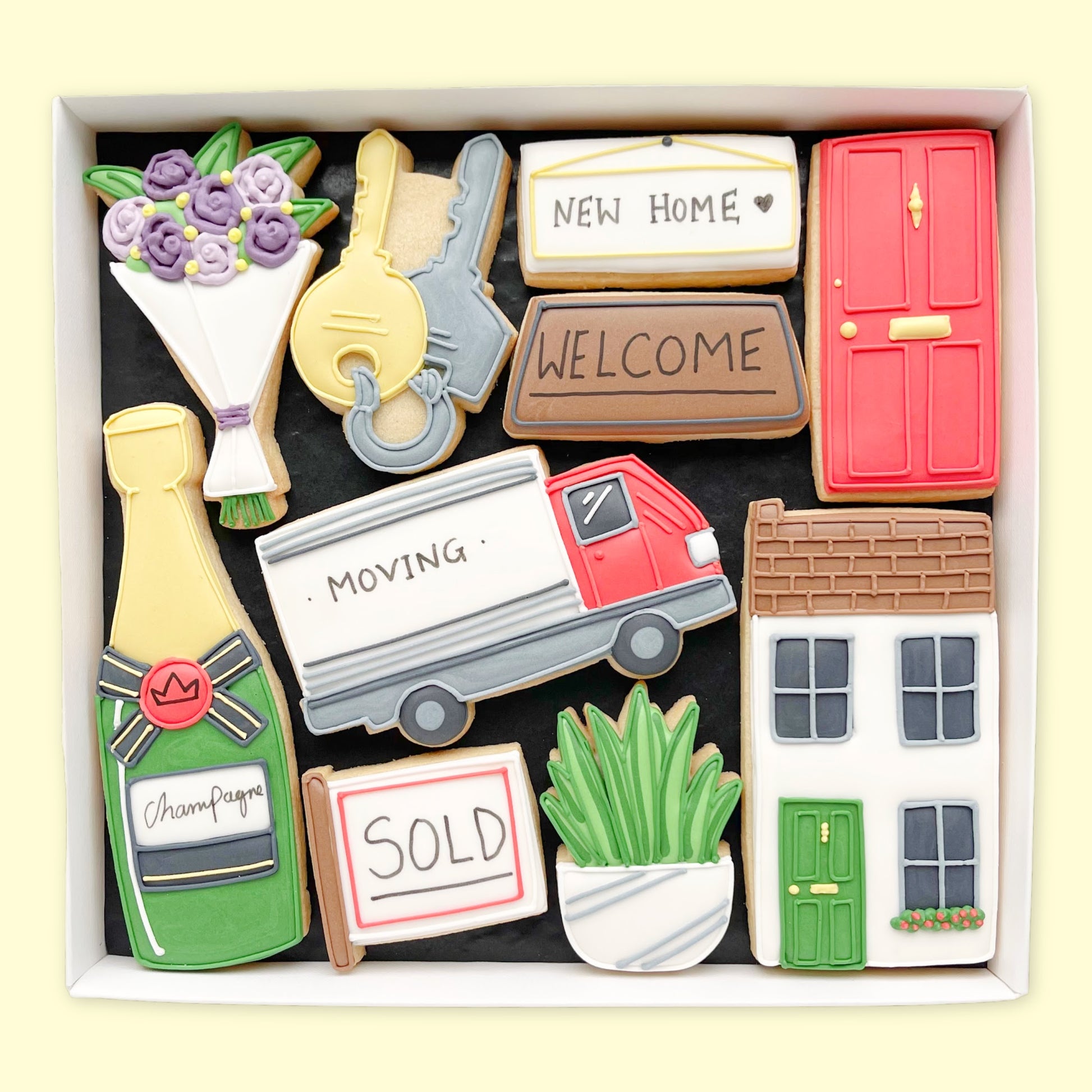 hand iced new home themed biscuits in an open white gift box by Katie's biscuit shop