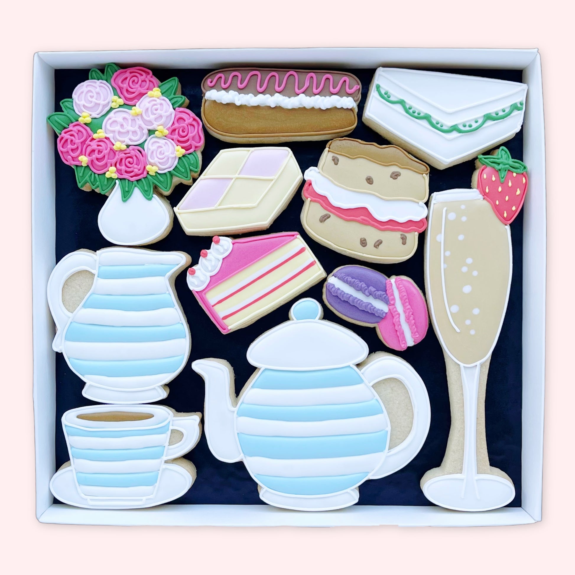Hand iced Afternoon tea themed hand iced biscuits by Katie's biscuit shop in an open white gift box 