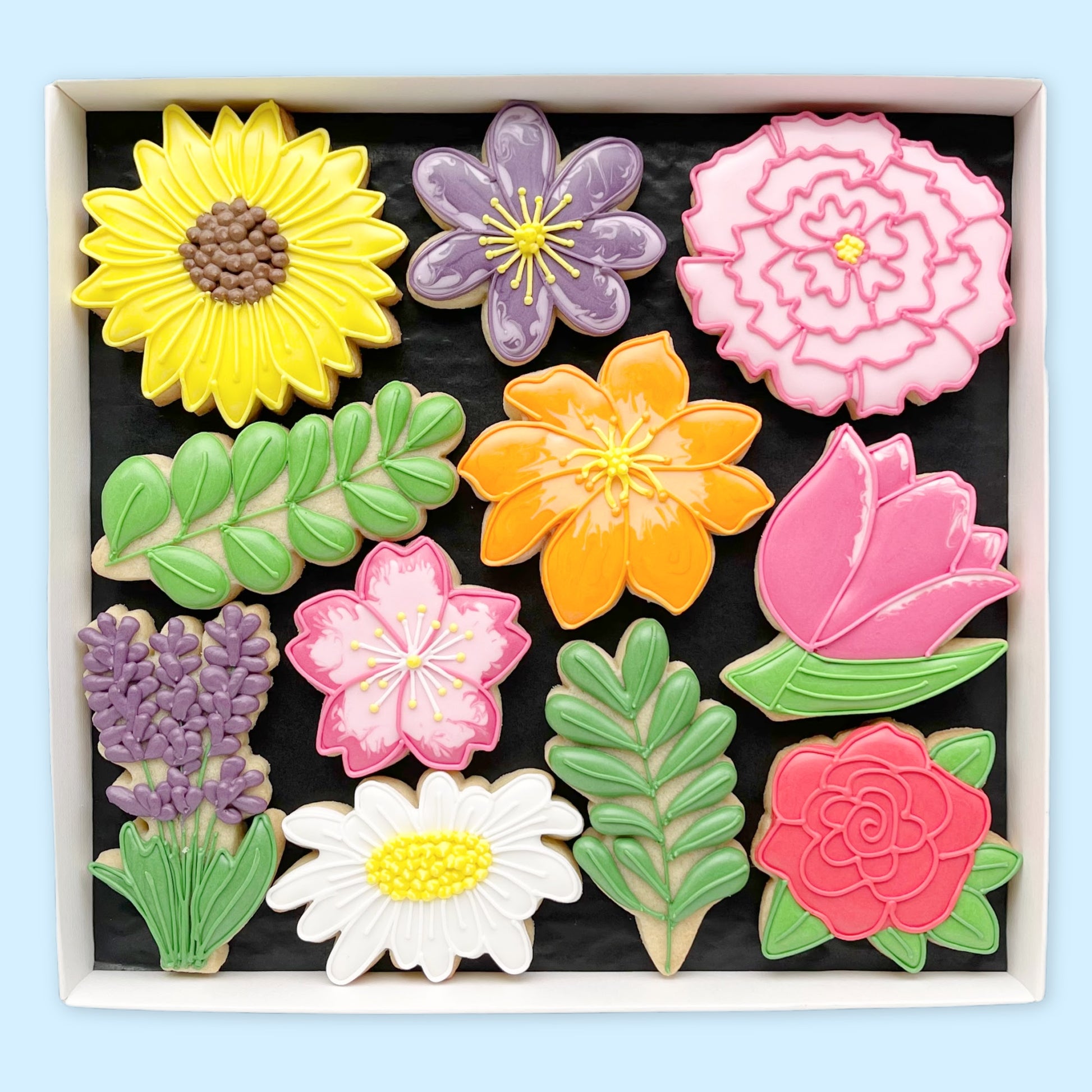 colourful hand iced flower biscuits by Katie's biscuit shop in an open white gift box 