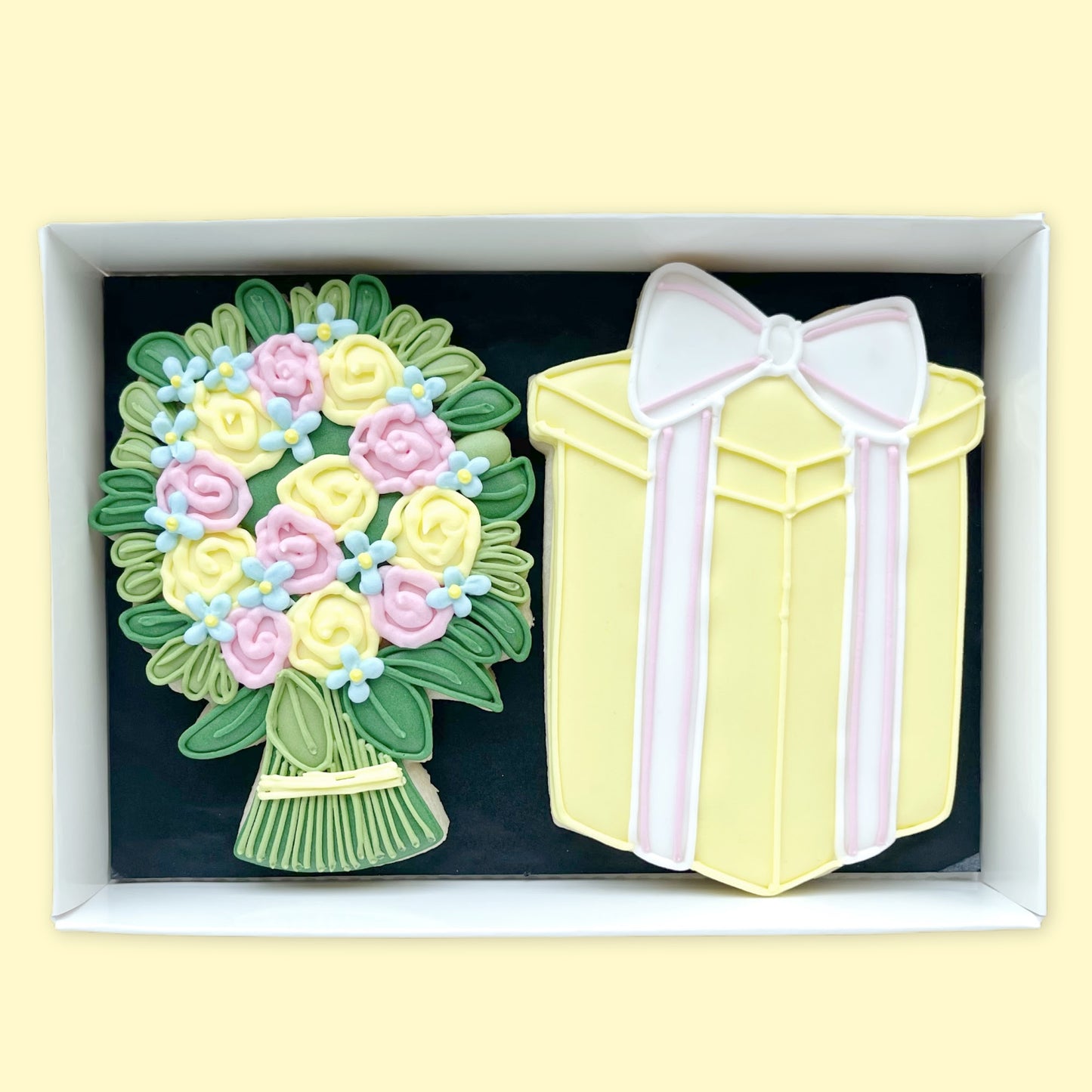 hand iced flower bouquet and gfit with bow  biscuits in yellow pink blue and green in a open white gift box by Katie's Biscuit shop 